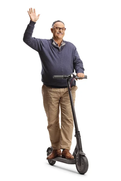 陽気成熟した男ライディングA電動スクーターと手を振っ白の背景に隔離 — ストック写真