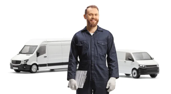 身穿制服的汽车修理工拿着剪贴板 站在被白色背景隔离的面包车前面 — 图库照片