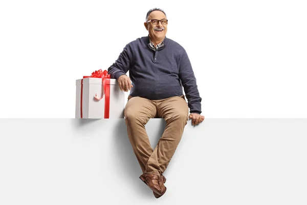 Happy Mature Man Gift Box Sitting Blank Panel Isolated White — Stock Photo, Image