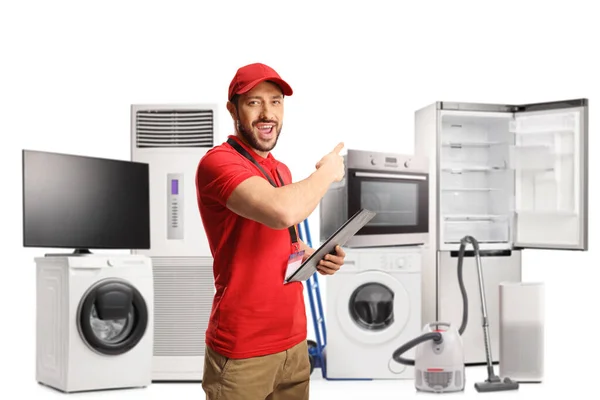 Cheerful Male Shop Assistant Holding Clipboard Pointing Electrical Appliances Isolated — Stock Photo, Image