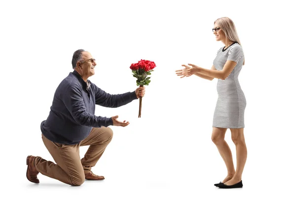 Mature Man Kneeling Giving Bunch Red Roses Young Woman Isolated — Stock Photo, Image