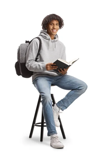 Afrykański Amerykański Student Plecakiem Siedzącym Krześle Trzymającym Otwartą Książkę Białym — Zdjęcie stockowe