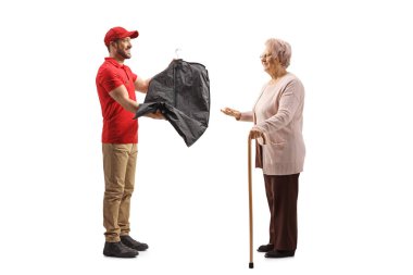 Yaşlı bir bayana kuru temizlemeci kıyafetleri teslim eden bir işçi.