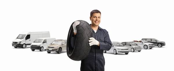 抛锚的车辆和一个机修工拿着一个白色背景隔离的轮胎 — 图库照片