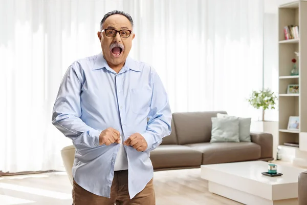 Shocked Mature Man Buttoning Small Shirt Living Room — Stock Photo, Image