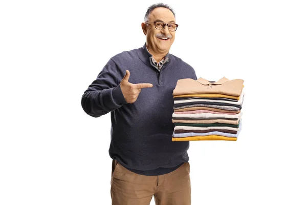 一个快乐而成熟的男人手里拿着一堆叠好的衣服 孤零零地靠在白色的背衬上 — 图库照片
