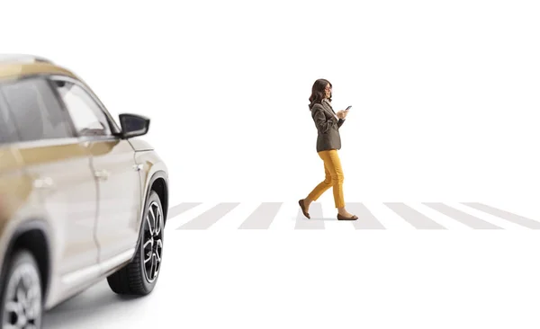車の運転と若い女性が通りを横断し 白い背景に隔離されたスマートフォンを使用して — ストック写真