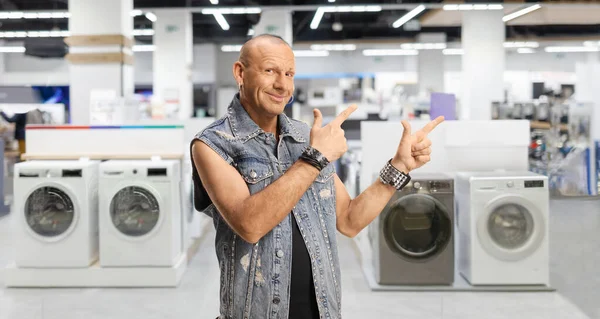 Glatzköpfiger Mann Jeansweste Zeigt Auf Ein Haushaltswarengeschäft — Stockfoto