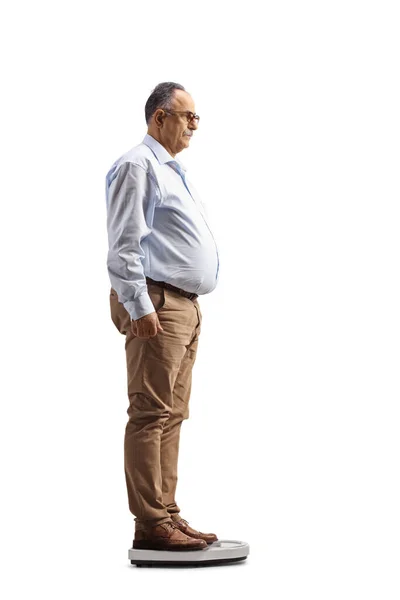 白い背景に隔離された体重計に立っている成熟した男の完全な長さプロファイルショット — ストック写真