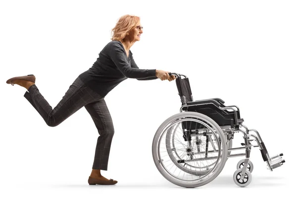 Полнометражный Снимок Взрослой Женщины Бегущей Толкающей Пустое Инвалидное Кресло Белом — стоковое фото