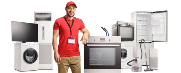 推销员靠在用白色背景隔开的烤箱和其他电器上 — 图库照片