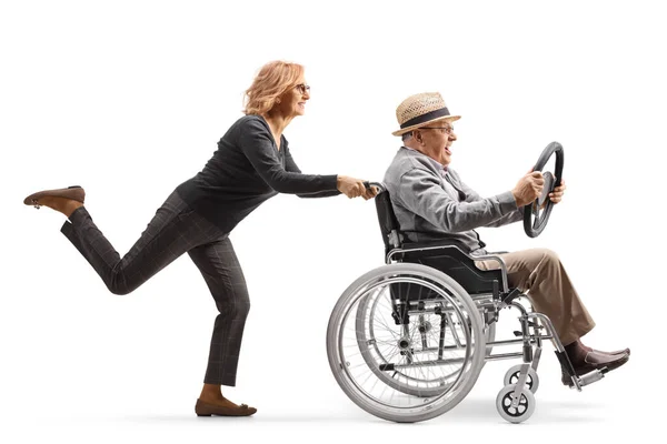 一个女人推着一个坐在轮椅上的成熟男人 手里拿着一个与白色背景隔离的方向盘 — 图库照片
