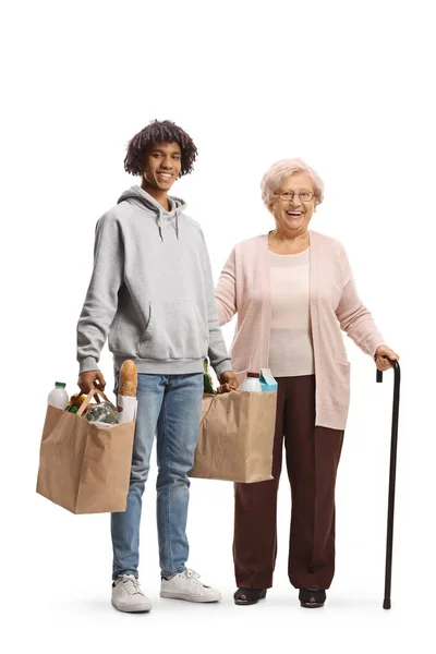 白い背景に隔離された高齢者の女性のための食料品袋を持っている若いアフリカ系アメリカ人男性 — ストック写真
