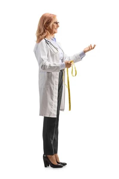 白い背景に隔離された測定テープを保持している女性栄養士の完全な長さプロファイルショット — ストック写真