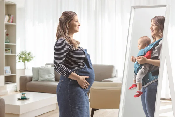 Schwangere Blickt Einen Spiegel Und Hält Ein Baby Hause Wohnzimmer — Stockfoto