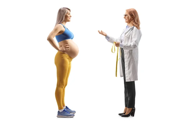 Female Doctor Talking Pregnant Woman Sportswear Isolated White Background — Stock Photo, Image