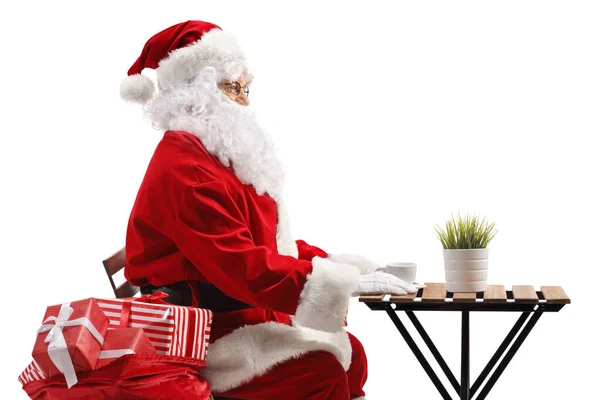 Święty Mikołaj Siedzi Przy Stoliku Odizolowanym Białym Tle — Zdjęcie stockowe