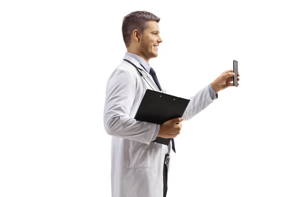 男医生手持在白色背景下隔离的智能手机的概况照片 — 图库照片