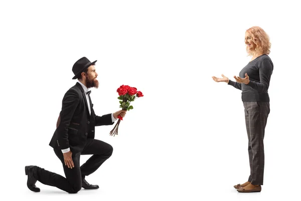 Mann Kniet Und Überreicht Einer Glücklichen Frau Eine Rote Rose — Stockfoto