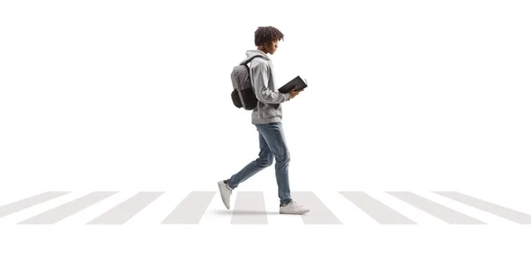 白い背景に隔離された横断歩道で本を読んでいる若いアフリカ系アメリカ人の男の完全な長さのプロフィール写真 — ストック写真