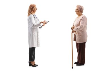Kadın bir doktorun beyaz arka planda izole edilmiş yaşlı bir kadın hastayla konuşurken tam boy profil fotoğrafı.