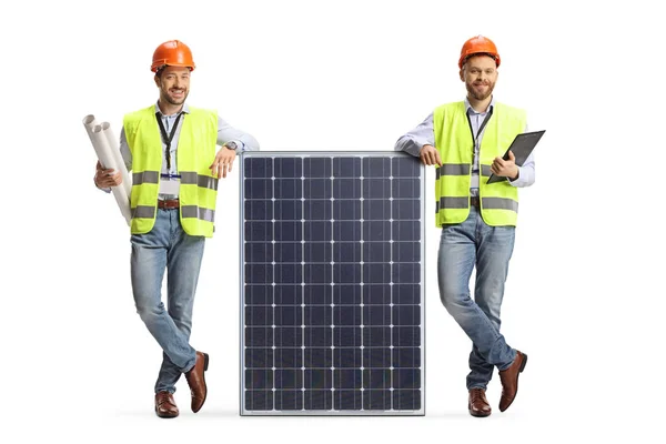 Ingenieros Masculinos Chalecos Seguridad Apoyados Panel Solar Aislado Sobre Fondo —  Fotos de Stock