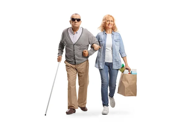 一个女人帮助一个失明的老年男子提着用白色背景隔离的购物袋 — 图库照片