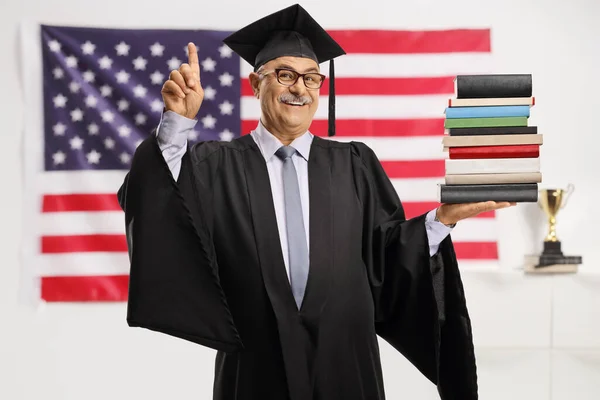 Mogen Man Examensrock Med Hög Böcker Och Peka Framför Amerikansk — Stockfoto
