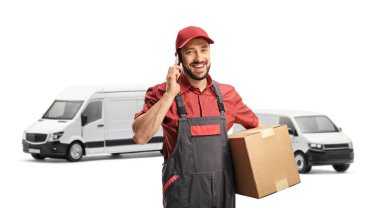 Erkek işçi cep telefonu kullanıyor ve beyaz arka planda izole edilmiş kamyonetlerin önünde karton kutu tutuyor.