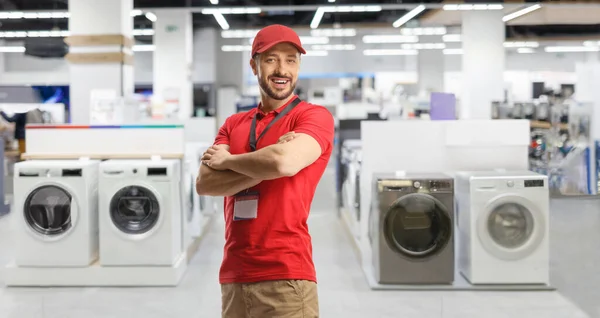 销售经理在一家装有洗衣机的电器商店里摆姿势 — 图库照片
