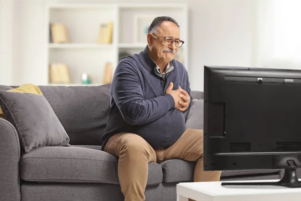 Mature Man Sitting Couch Holding His Heart Front Home — Stock Photo, Image