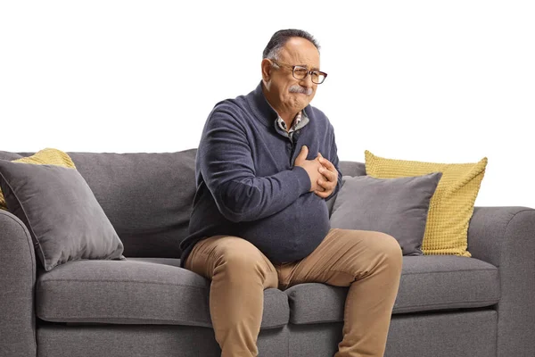 Dojrzały Mężczyzna Siedzi Kanapie Objawy Zawału Serca Izolowane Białym Tle — Zdjęcie stockowe