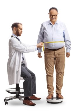 Doktor beyaz arka planda izole edilmiş olgun bir adamdan bel ölçüleri alıyor.