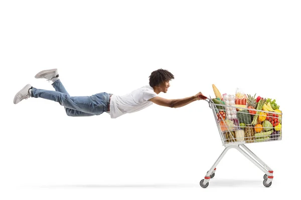 African American Guy Flying Holding Shopping Cart Healthy Food Isolated — Stock Photo, Image