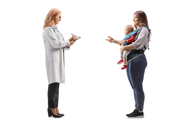 白い背景に隔離された医師と会話をしている赤ん坊を持つ母親の完全な長さのプロフィール写真 — ストック写真