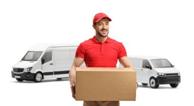 Beyaz arka planda izole edilmiş iki beyaz minibüsün önünde duran paketli bir teslimatçı.