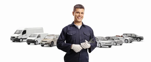 Lächelnder Junger Mechaniker Mit Vielen Fahrzeugen Dahinter Isoliert Auf Weißem — Stockfoto