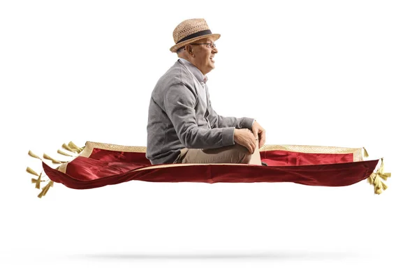 一名老年绅士穿着红色天鹅绒地毯在白色背景下飞行的侧面照片 — 图库照片
