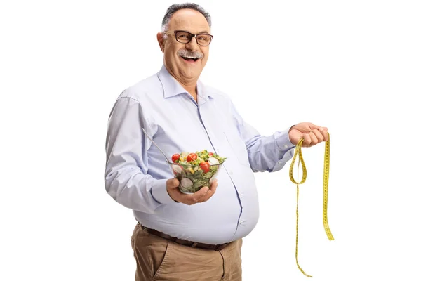 Volwassen Man Met Een Salade Een Meetlint Geïsoleerd Witte Achtergrond — Stockfoto
