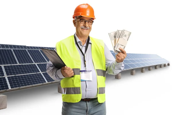 Ώριμος Μηχανικός Μπροστά Από Ηλιακούς Συλλέκτες Κρατώντας Χρήματα Που Απομονώνονται — Φωτογραφία Αρχείου