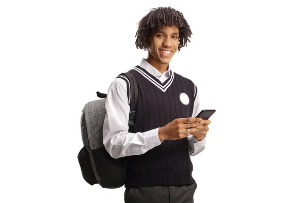 白い背景に隔離されたスマートフォンと笑顔を使用して制服を着たアフリカ系アメリカ人男性学生 — ストック写真