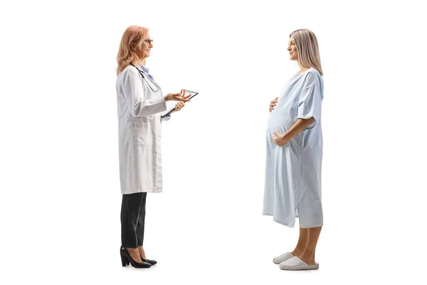 白地に隔離された入院中の妊婦と話す女性医師の完全長プロファイルショット — ストック写真