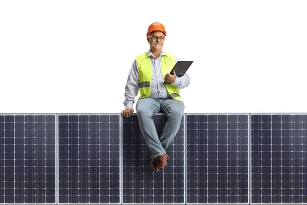 Dojrzały Inżynier Kamizelce Kasku Siedzący Panelu Słonecznym Białym Tle — Zdjęcie stockowe