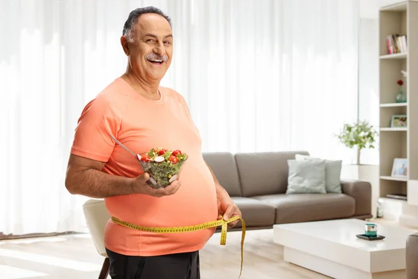 Mature Man Sportswear Holding Salad Measuring Waist Home Living Room — Stock Photo, Image