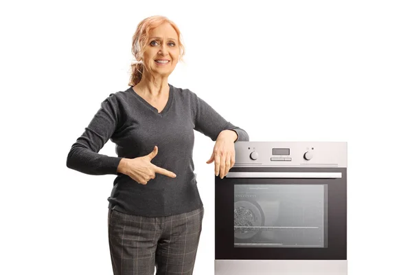 Smiling Woman Leaning Oven Pointing Isolated White Background — Stock Photo, Image