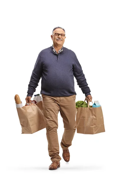 白い背景に隔離された食料品袋を持っている成熟した男の完全な長さの肖像画 — ストック写真