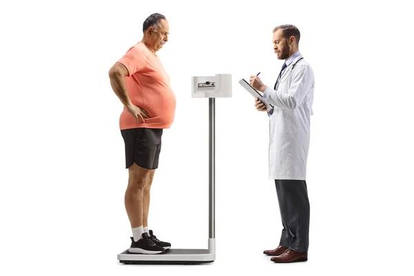白地に隔離された熟年の体重を調べる医者 — ストック写真