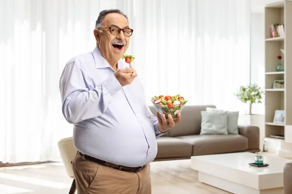 Mature Man Standing Eating Salad Living Room Home — Stock Photo, Image