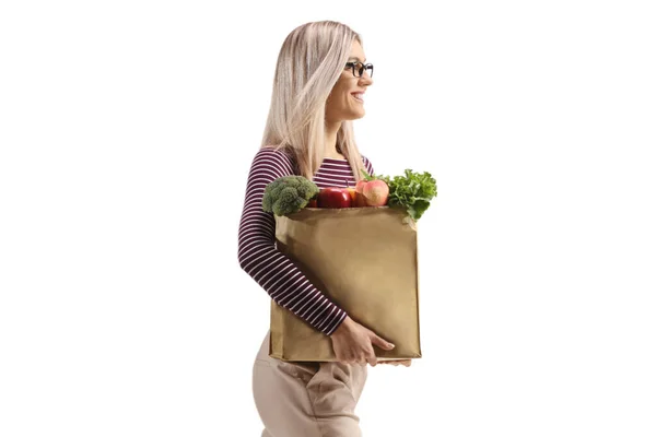 白地に隔離された食料品袋を持って歩くブロンドの女性 — ストック写真