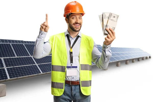 Muž Inženýr Bezpečnostní Vestou Hardhat Drží Hromady Peněz Před Fotovoltaických — Stock fotografie